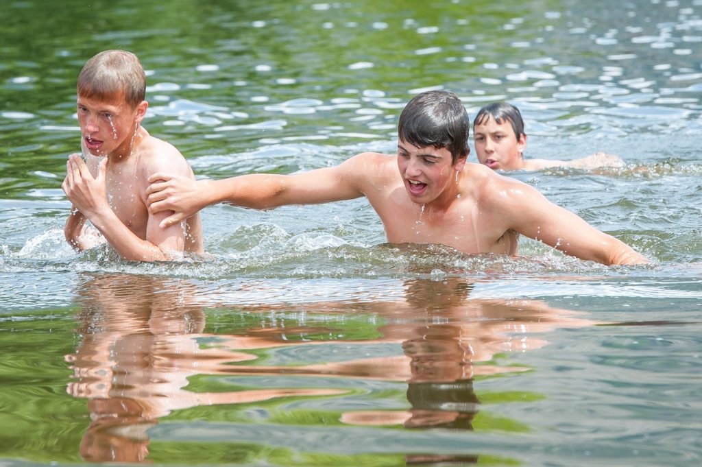 Students Jason Lynch, Jaedan Holz and Cole Rezka emerge from the water after completing the swimming portion of the Storm the Wall relay. (Richard McGuire photo)