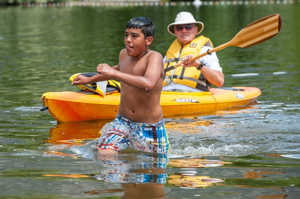 Antonio Mora runs ashore after completing his swim while volunteer Bob Sherwood stands by in a kayak. Mora was competing in Osoyoos Secondary School's Storm the Wall relay. (Richard McGuire photo)