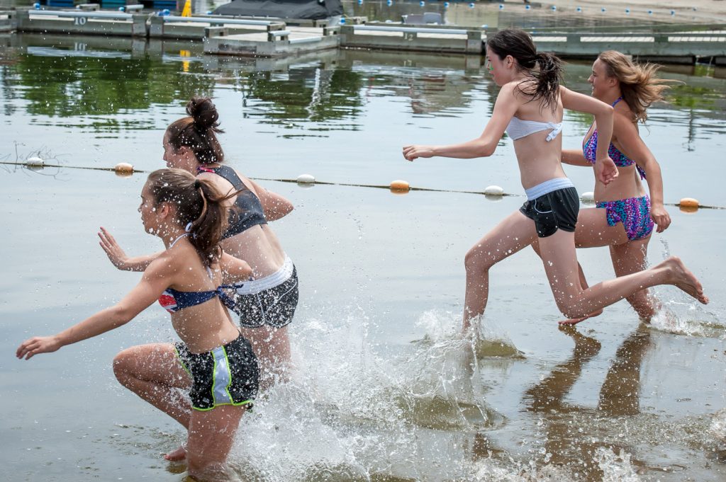 Janessa Silva, Angel Thomas, Christen Rausch and Johanne Jeffries run into the water to complete the swimming portion of the Storm the Wall relay at OSS. (Richard McGuire photo)