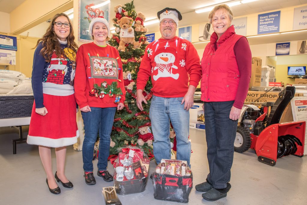 Trudy and Marvin Johnston (centre) were named the first and second place winners of the Sears Ugly Sweater Contest on Saturday. Mayor Sue McKortoff came out to congratulate them only to discover their sweatshirts were ones she recently donated to the United Church Thrift Shop. The Johnstons, however, had embellished them with blinking lights and other decorations. At left is Osoyoos Royalty Princess Bailey Toepfer, the daughter of Sears owners Theresa and Spencer Toepfer. (Richard McGuire photo)