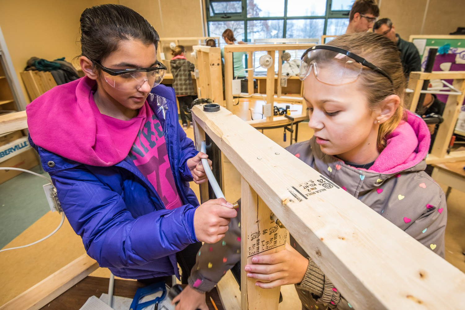 Navneet Sandhu (left) and Hanna Estby fit a pipe through holes in a frame. The two are Grade 6 students at Osoyoos Elementary School. Last week students were introduced to a number of building trades. (Richard McGuire photo)