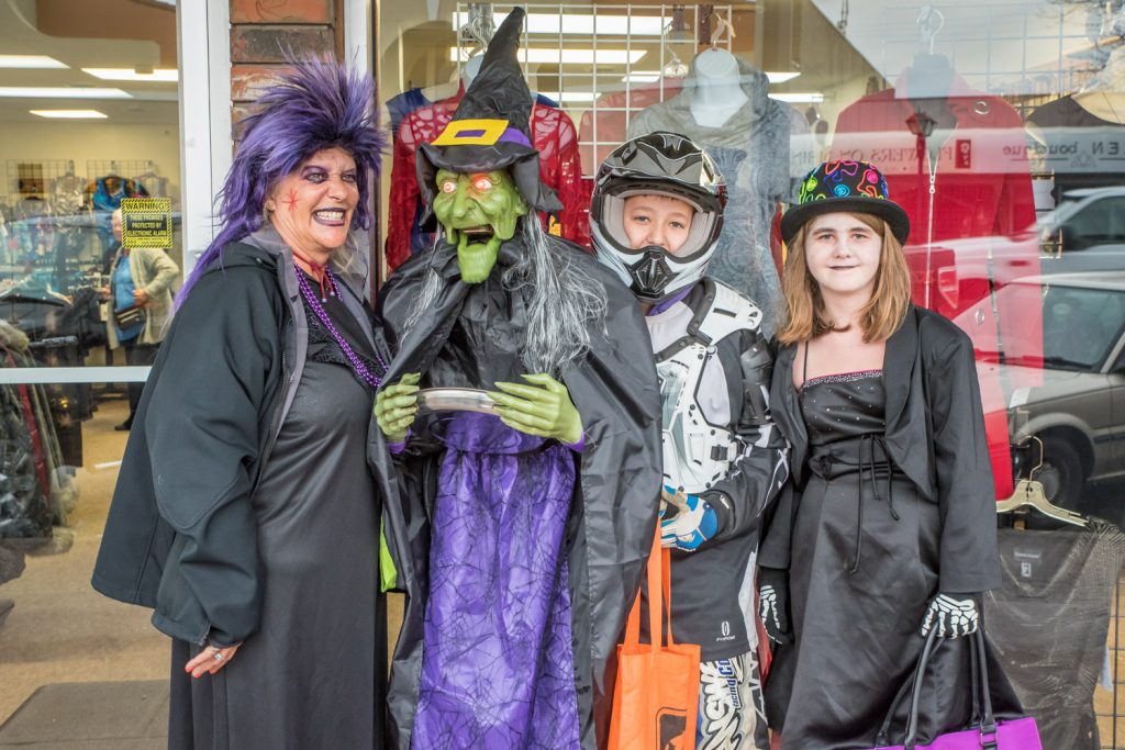 Which witch is which? Susan Doggett (left) poses with Gretchen the witch in front of Sonia's Boutique. Gretchen's eyes lit up in red and her jaw moved as she cackled. To the right area Lukas Doggett and Cassidy Zaye. They were among the many people of all ages enjoying Trick or Treat Main Street on Saturday. (Richard McGuire photo)