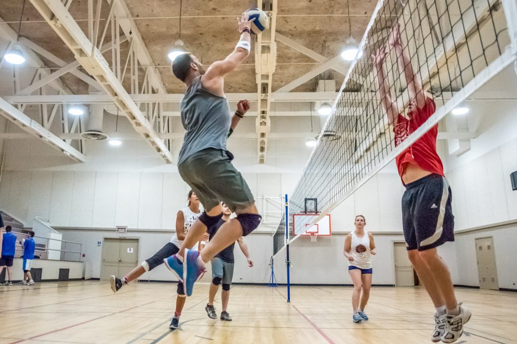 Tyler Fecyk, of Hogan's Heroes, leaps for a high ball (left) while Ryan Dunkley of Desert Hills prepares to hit it back. (Richard McGuire photo)