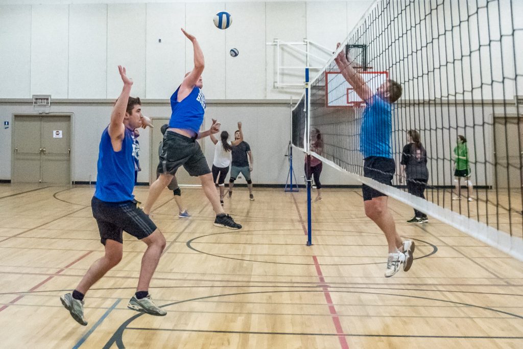 Randy Houle of Here Come the Horses jumps for the ball while Kenton Gilchrist of Desert Hills jumps to try to block it (right). At left, Jonathan Stermescheg is ready to deflect it if it comes his way. (Richard McGuire photo)