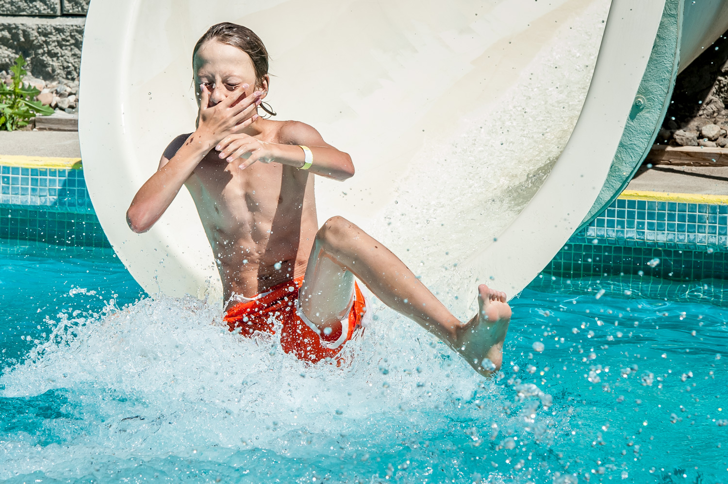 Ethan Kuzmak, 12, of Osoyoos braces for the water as he reaches the end of a waterslide at Osoyoos Campground and Waterslides. Kuzmak was visiting the slides off Lakeshore Drive with other children from Cactus Kids Club Day Camp. (Richard McGuire photo)