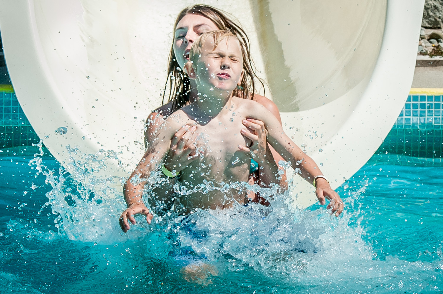 Elizabeth Burnett helps Victor Wichar as they reach the end of a waterslide at Osoyoos Campground and Waterslides. They were visiting the slides off Lakeshore Drive with other children from Cactus Kids Club Day Camp. (Richard McGuire photo)