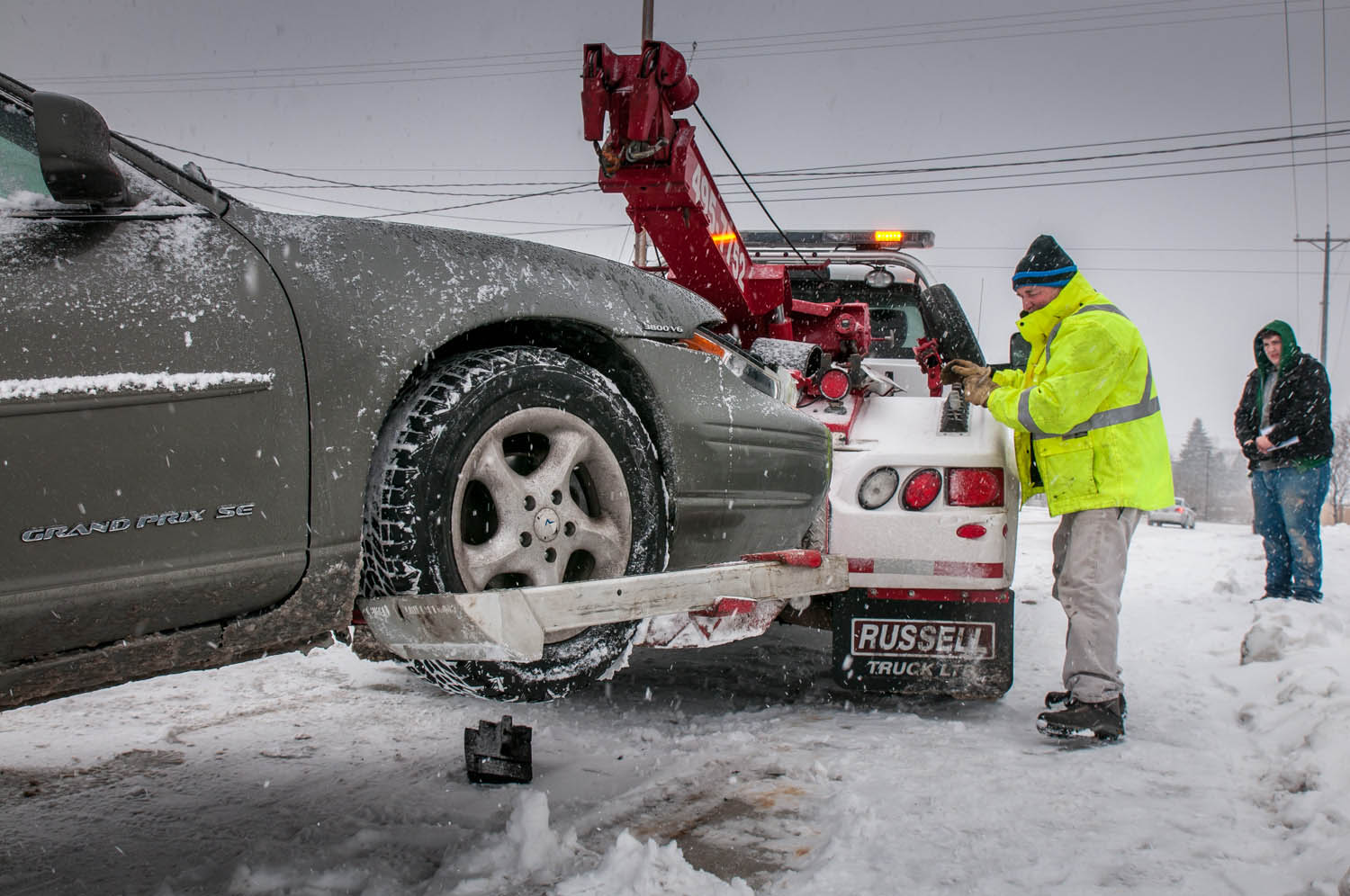 Slippery roads make driving hazardous. Laurence Usher of Usher’s Towing hooks up a car that slid into an intersection and suffered a fender bender. (Richard McGuire file photo)