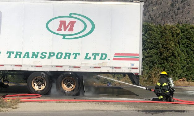 Firefighters extinguish smoking semi-trailer truck wheels